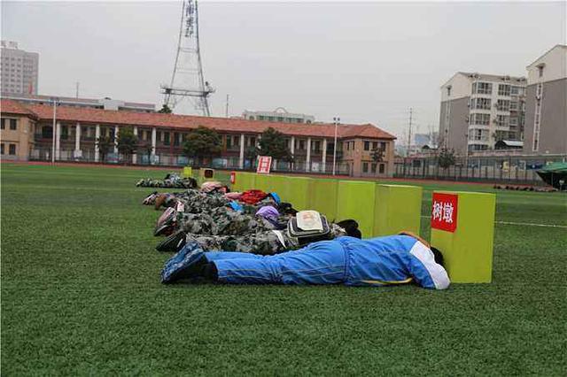 图注:中学生开展核辐射防护技能培训,图为参训的中学生匍匐卧倒在障碍