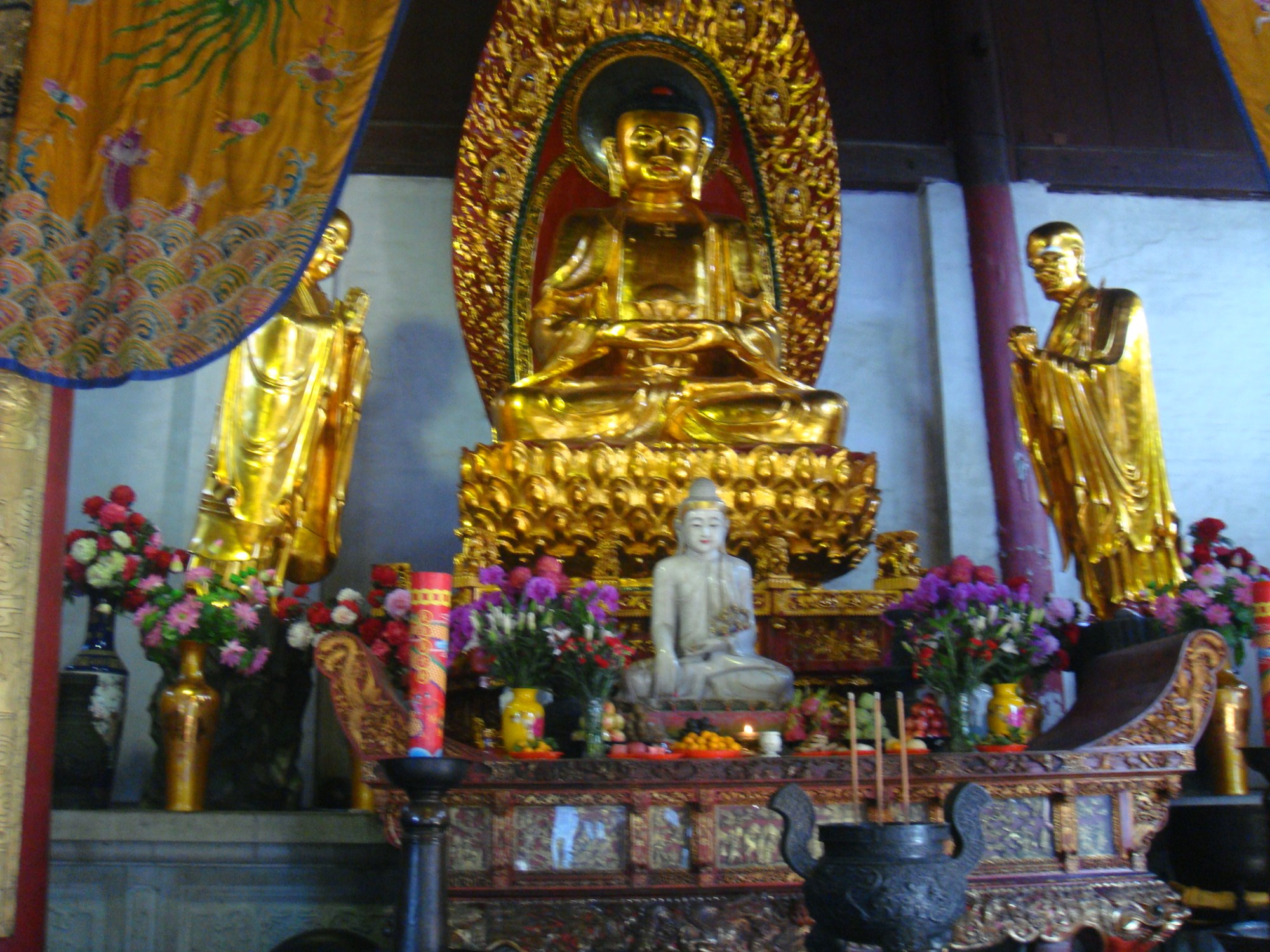 大雄宝殿前的宝鼎精工细雕,殿内供奉的是释迦牟尼佛,大殿两侧是十八