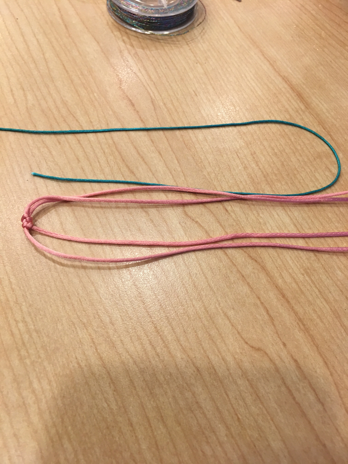 粉色线对折后,在中间位置编织两个蛇结.6股彩金线1.5米.