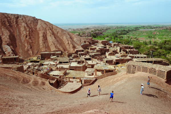 村子坐落在火焰山脚下的小绿洲中,房屋均是以黄粘土制坯建成的窑房